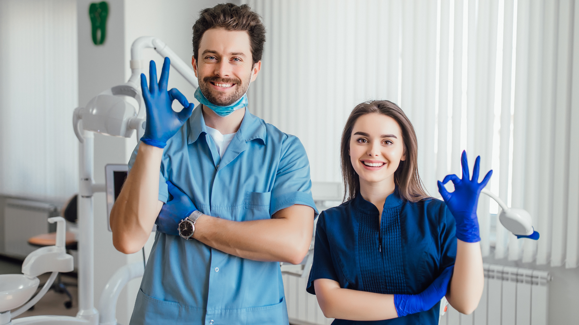 photo-smiling-dentist-standing-with-arms-crossed-with-her-colleague-showing-okay-sign