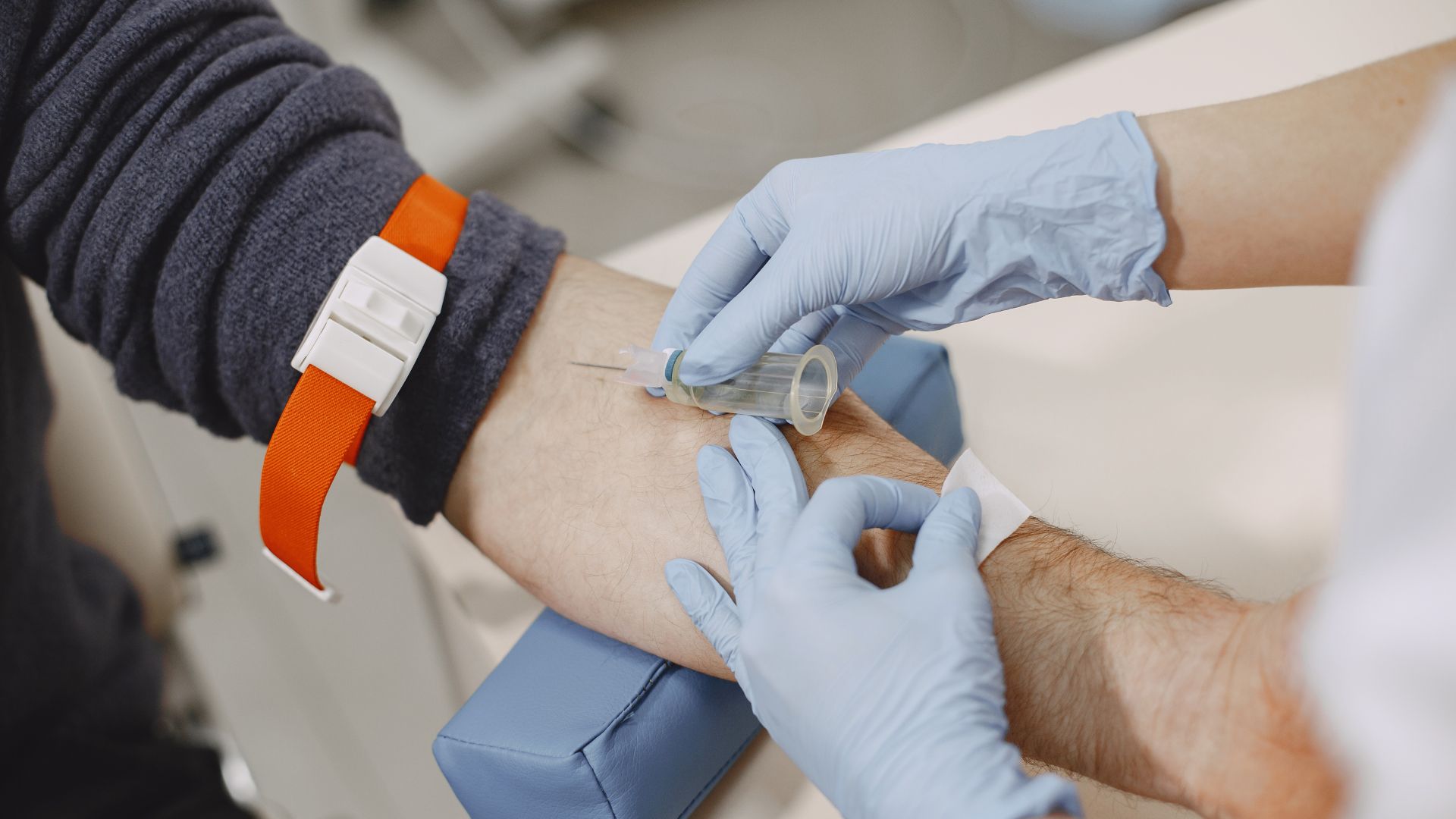 Nurse taking blood sample from patient at the doctors office