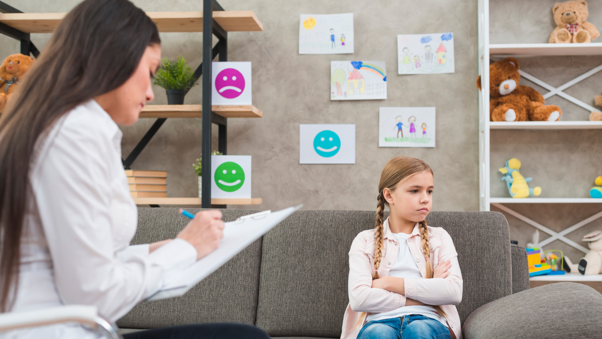 depressed girl sitting sofa with female psychologist writing note clipboard